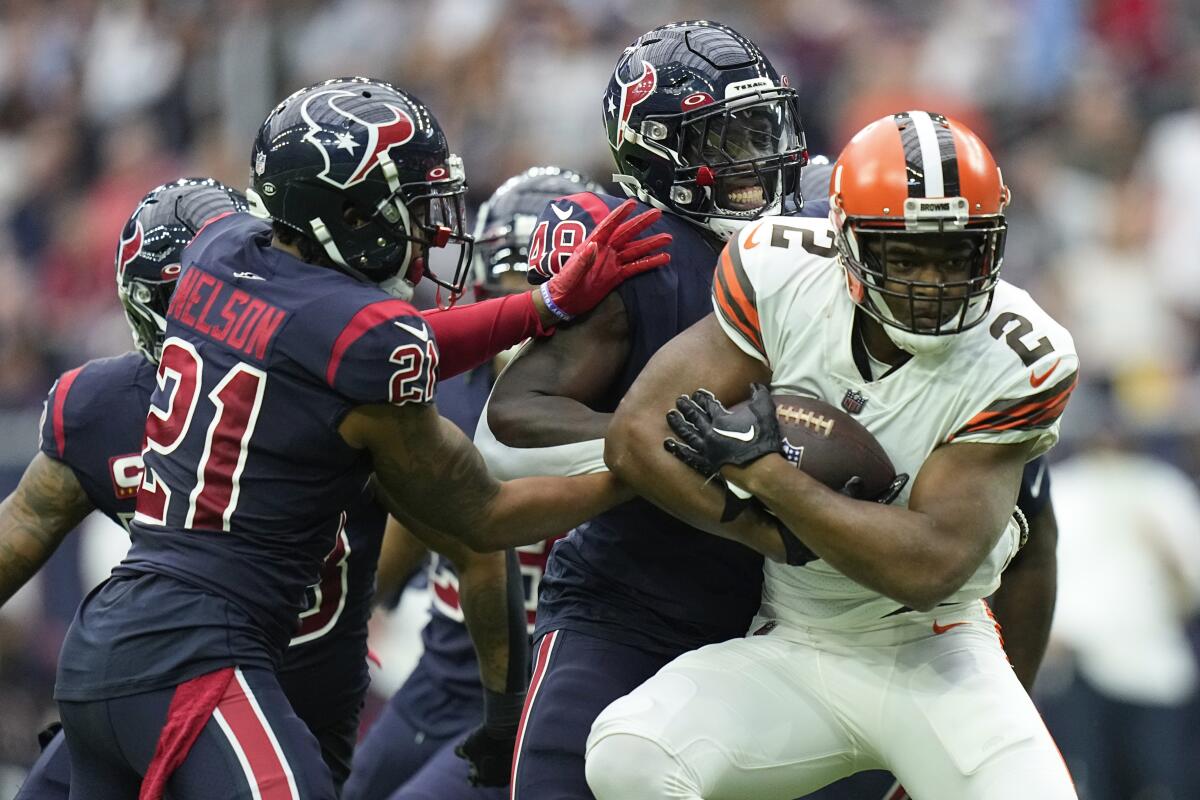 Cleveland Browns wide receiver Amari Cooper (2) is tackled by Houston Texans cornerback Steven Nelson (21) and Christian Harris (48) during the first half of an NFL football game between the Cleveland Browns and Houston Texans in Houston, Sunday, Dec. 4, 2022,. (AP Photo/Eric Gay)