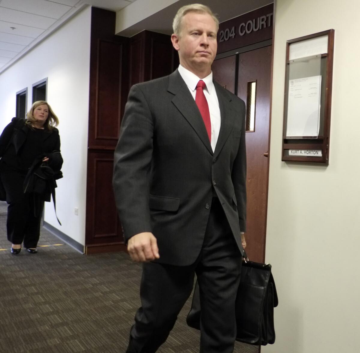 District Atty. George Brauchler leaves district court in Centennial, Colo., after a hearing in the James Holmes case. Brauchler requested a second mental evaluation of Holmes. As a result, district judge Carlos A. Samour Jr. postponed the start of the trial, which had been scheduled for February.