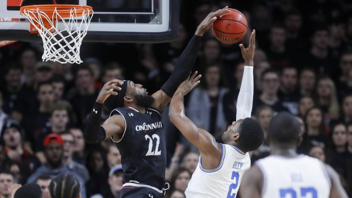 Cincinnati's Eliel Nsoseme (22) blocks a shot by UCLA's Cody Riley (2) during the first half.