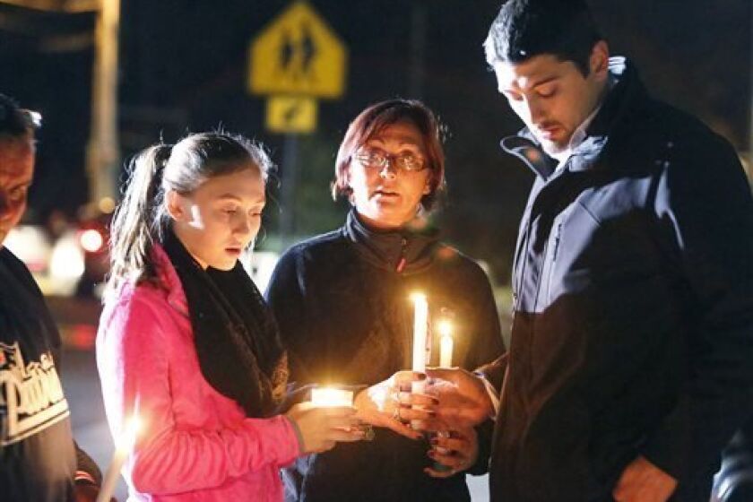 Parents and Danvers High School students hold candlelight vigil to mourn the death of Colleen Ritzer, a 24-year-old math teacher at Danvers High School, on Wednesday, Oct 23, 2013, in Danvers, Mass. Ritzer's body was found in woods behind the school, and Danvers High School student Philip Chism, 14, who was found walking along a state highway overnight, was charged with killing her. (AP Photo/ Bizuayehu Tesfaye)