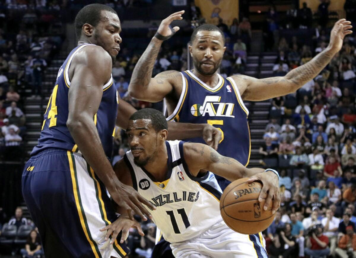 Grizzlies point guard Mike Conley tries to drive past Jazz forward Paul Millsap and guard Mo Williams (5) in the first half Wednesday night in Memphis.