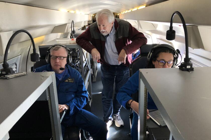 Marty Ralph, (center) director of the Center for Western Weather and Water Extremes at Scripps Institution of Oceanography, looks at meteorologist Rich Henning's computer as they track data being collected on an atmospheric river over the Pacific. Meteorologist Sofia de Solo (right) was checking the data transmitted by dropsondes as they drifted down through the storm.