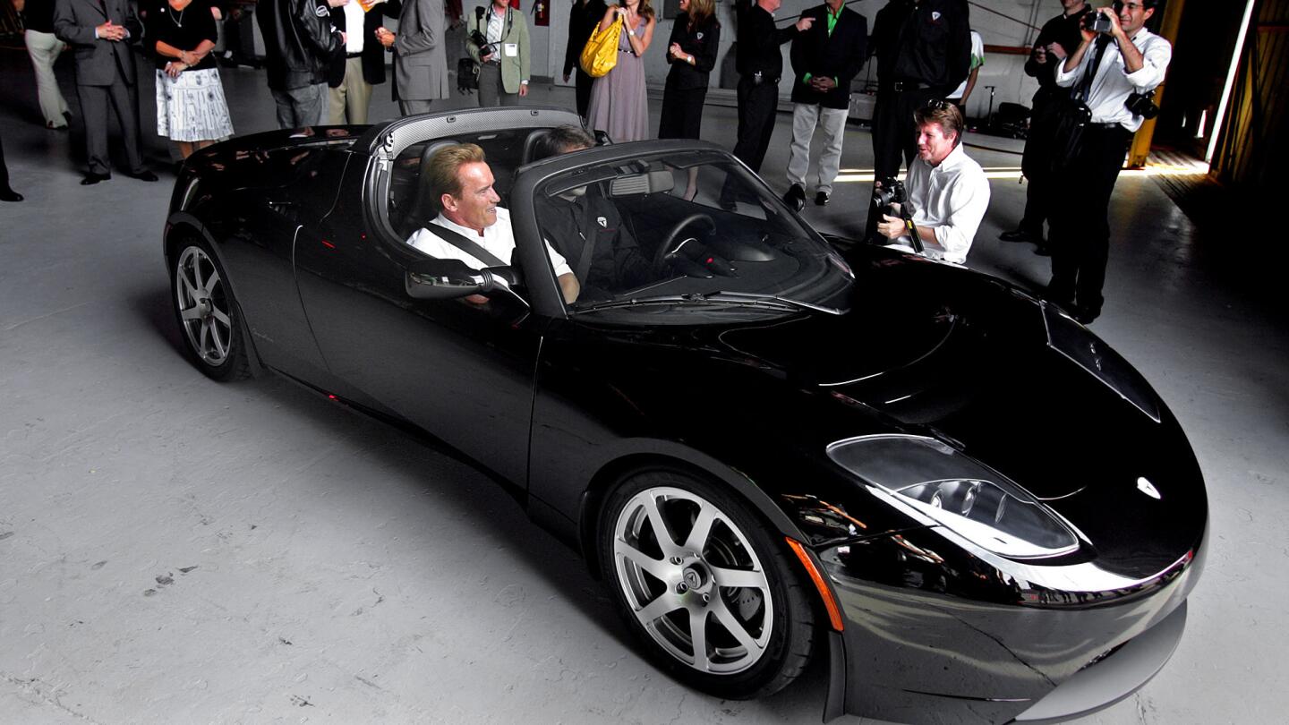 Then-Gov. Arnold Schwarzenegger takes a quick ride in the new Tesla Motors electric roadster in July 2006.