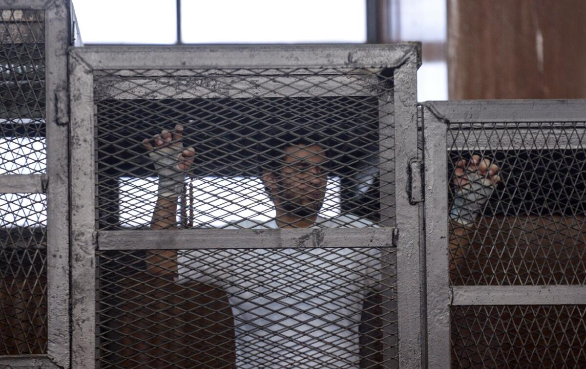 Despite its crackdowns on the press and political parties, Egypt was certified Tuesday to receive U.S. aid. Here, a defendant in custody gestures Tuesday during a trial of 20 people accused of being linked to the banned Muslim Brotherhood.