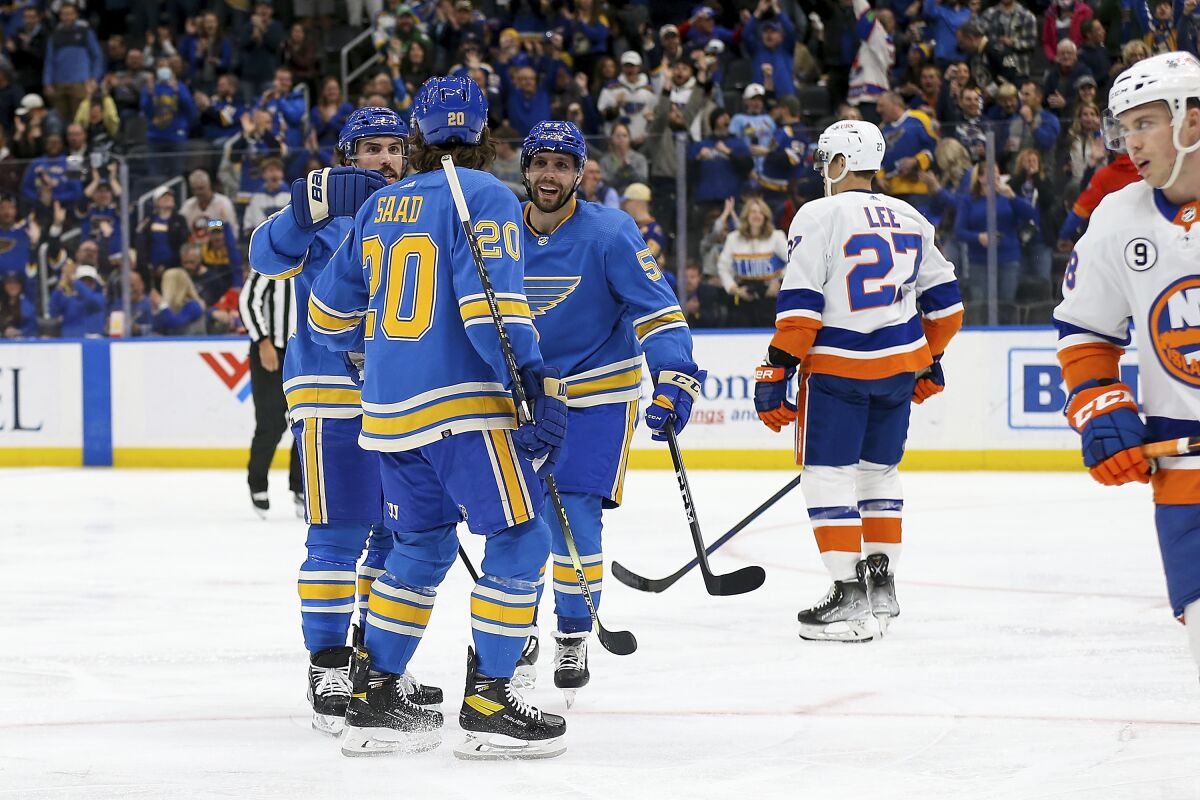 Members of the St. Louis Blues celebrate after scoring a goal during the second period of an NHL hockey game against the New York Islanders Saturday, April 9, 2022, in St. Louis. (AP Photo/Scott Kane)