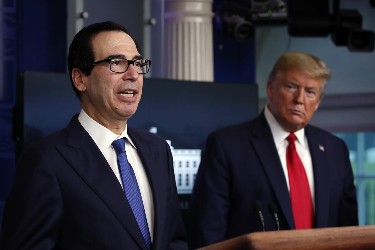 Treasury Secretary Steven T. Mnuchin speaks at the White House in April as President Trump watches.