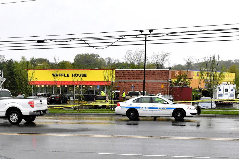 Law enforcement investigate the scene outside a Waffle House where four people were killed
