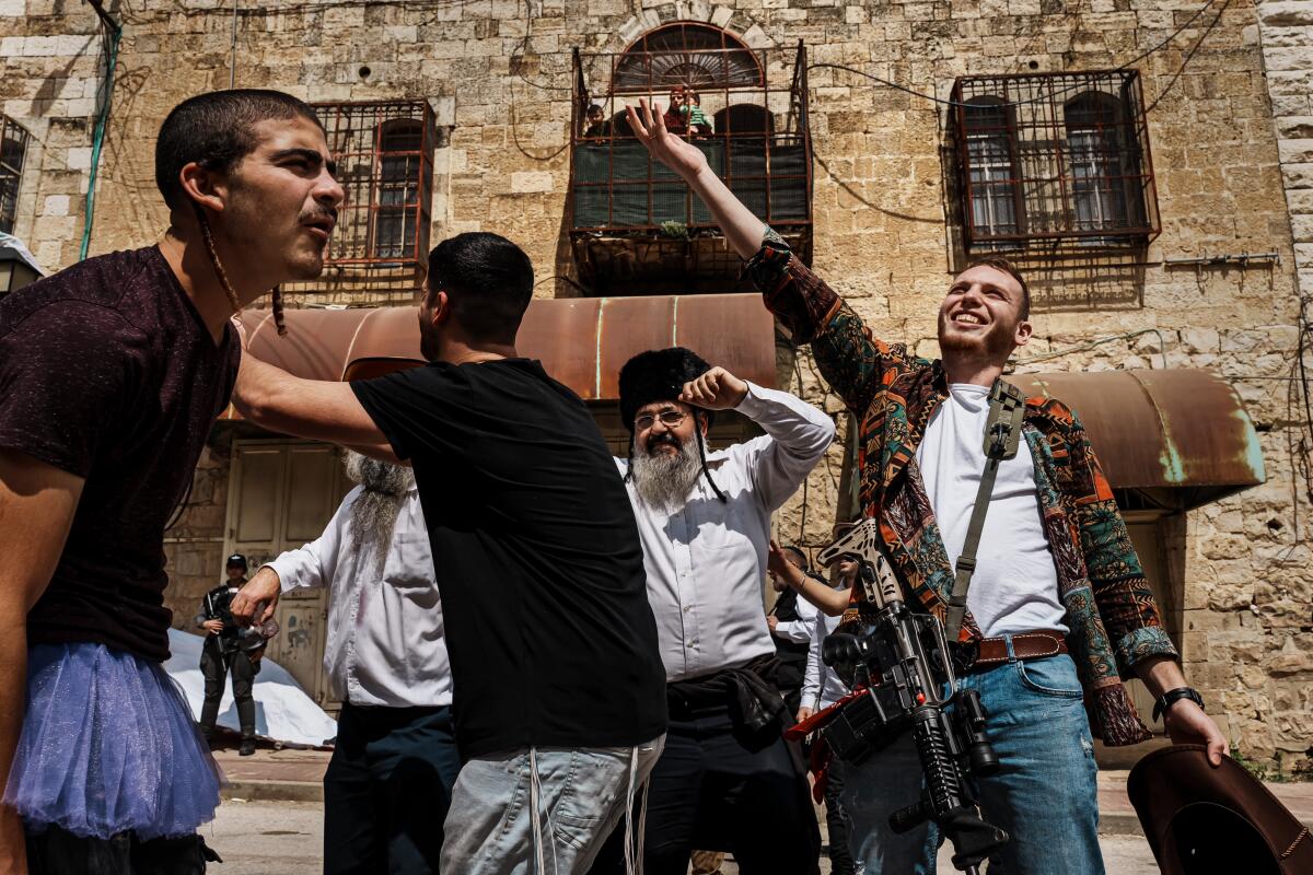 Religious Israeli dress up in costumes march  in a parade to celebrate Purim in Hebron, Occupied West Bank , in March
