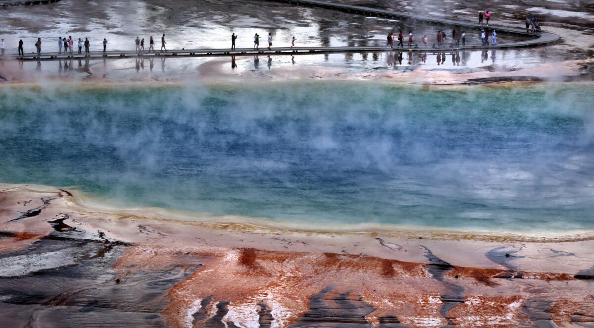 YELLOWSTONE, WYOMING, JULY 23, 2015: Crowds of visitors on the wooden walkways at the Midway Geyser Basin walk through the steam clouds around the colorful Grand Prismatic Spring in Yellowstone National Park July 23, 2015(Mark Boster / Los Angeles Times ).