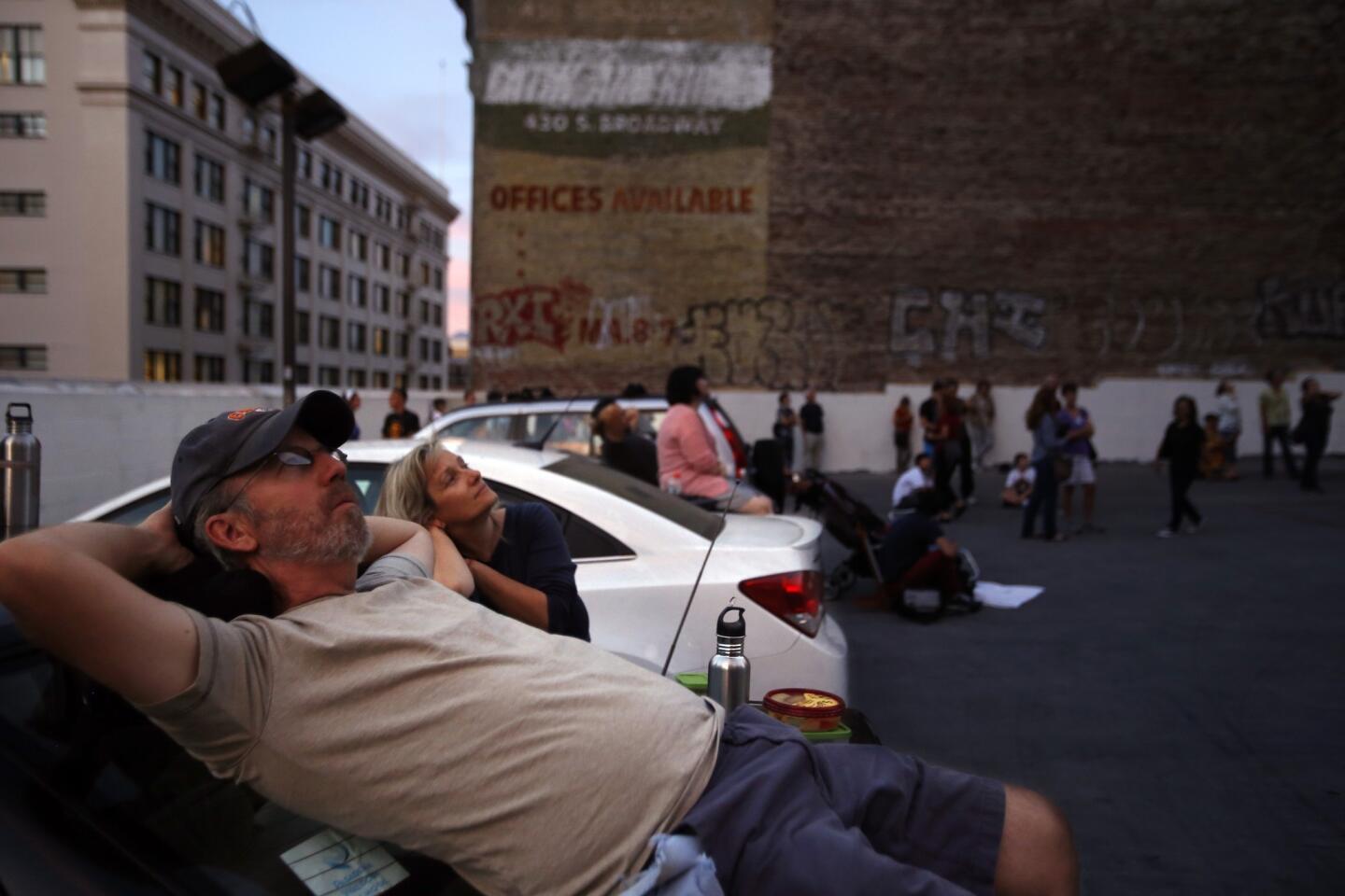 John Short, left, and his wife Mary Beth joined around 50 people who gathered on top of a parking garage to watch dozens of Vaux's swifts swarm before bedding down for the night in a chimney on top of a building at 5th Street and Broadway in downtown Los Angeles on Friday.
