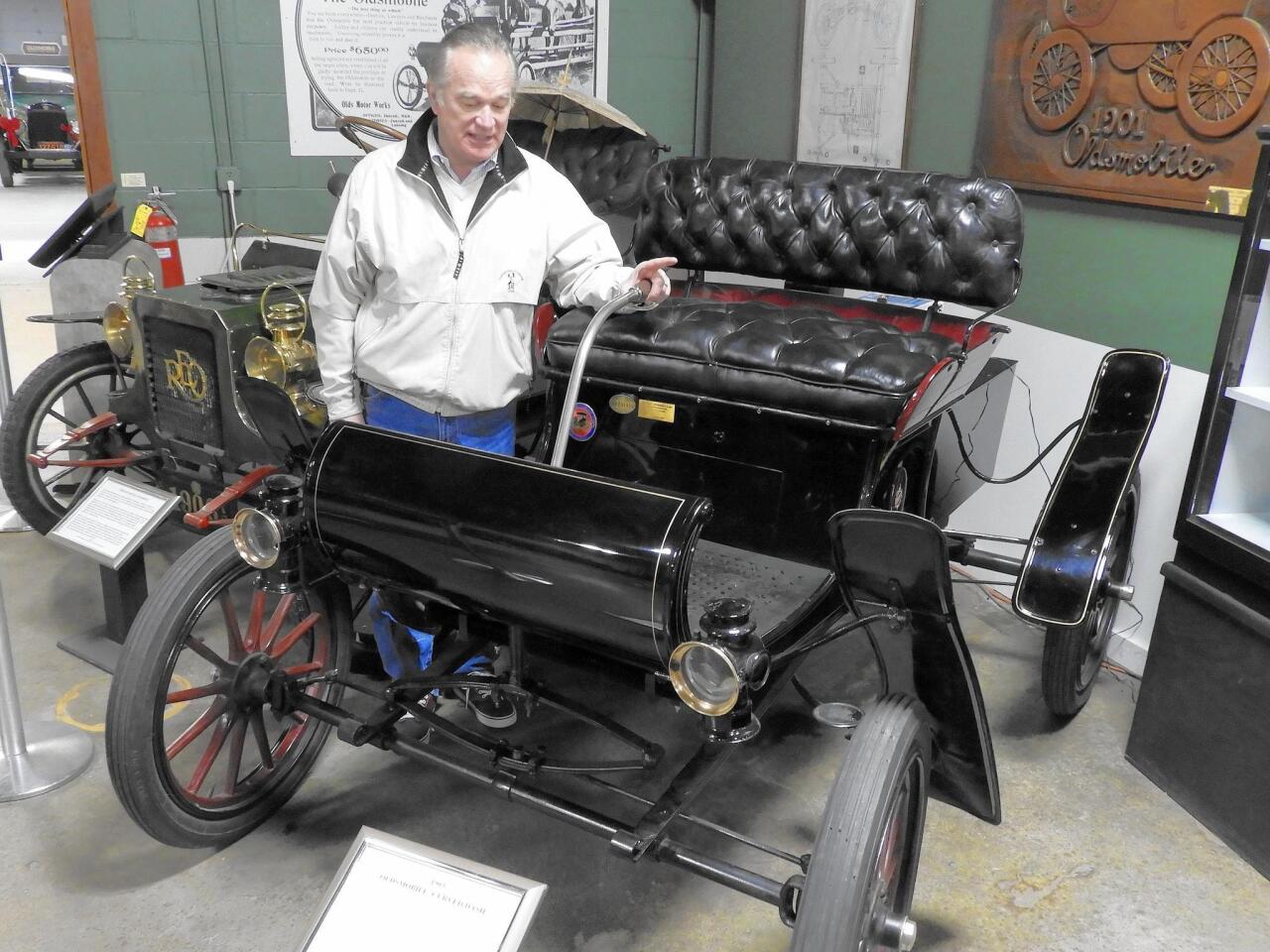 Bill Adcock of the R.E. Olds Transportation Museum in Lansing, Mich., admires one of the earlier vehicles in his collection: a 1904 Oldsmobile Curved-Dash.