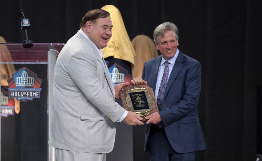 Pro Football Hall of Fame president David Baker hands Sam Farmer the Dick McCann Award.
