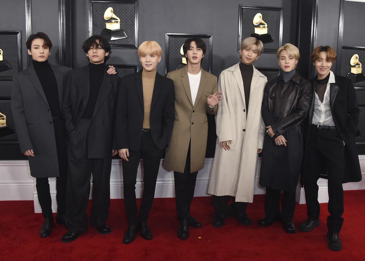 Seven members of BTS pose in a line at the Grammys.