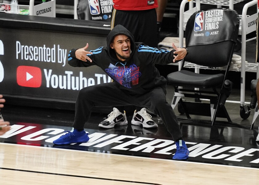 Atlanta Hawks' Trae Young, who did not play, celebrates a score during the second half against the Milwaukee Bucks in Game 4 of the NBA basketball Eastern Conference finals Tuesday, June 29, 2021, in Atlanta. (AP Photo/Brynn Anderson)