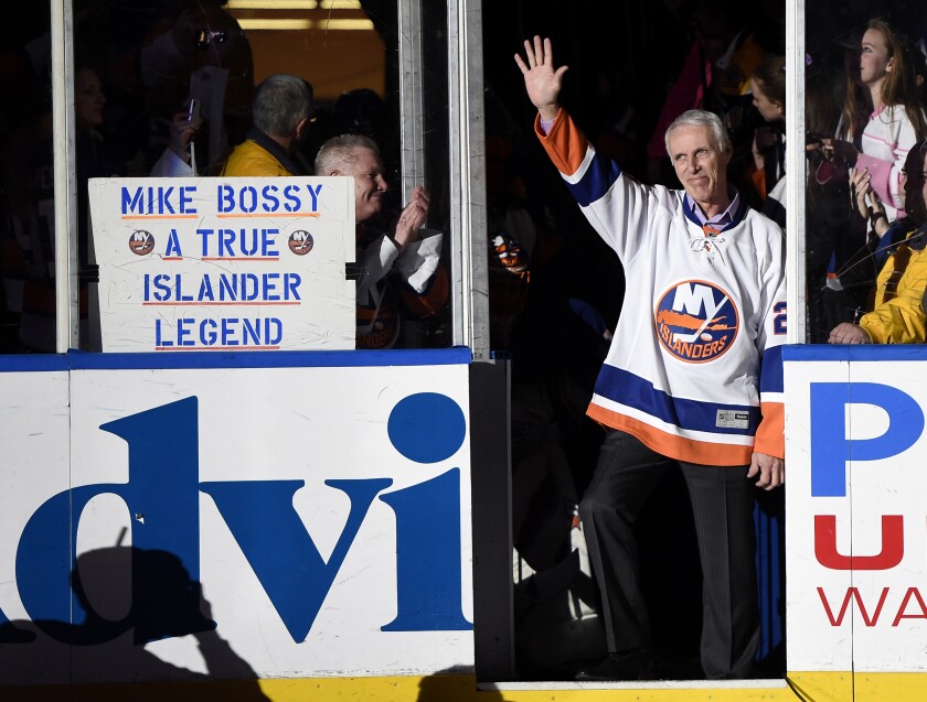 FILE - Hockey Hall of Famer and former New York Islander Mike Bossy waves to fans as he is introduced before the NHL hockey game between the Islanders and the Boston Bruins at Nassau Coliseum on Thursday, Jan. 29, 2015, in Uniondale, N.Y. Bossy dropped a ceremonial first puck. Bossy, one of hockey’s most prolific goal-scorers and a star for the New York Islanders during their 1980s dynasty, died Friday, April 15, 2022, after a battle with lung cancer. He was 65. (AP Photo/Kathy Kmonicek, File)