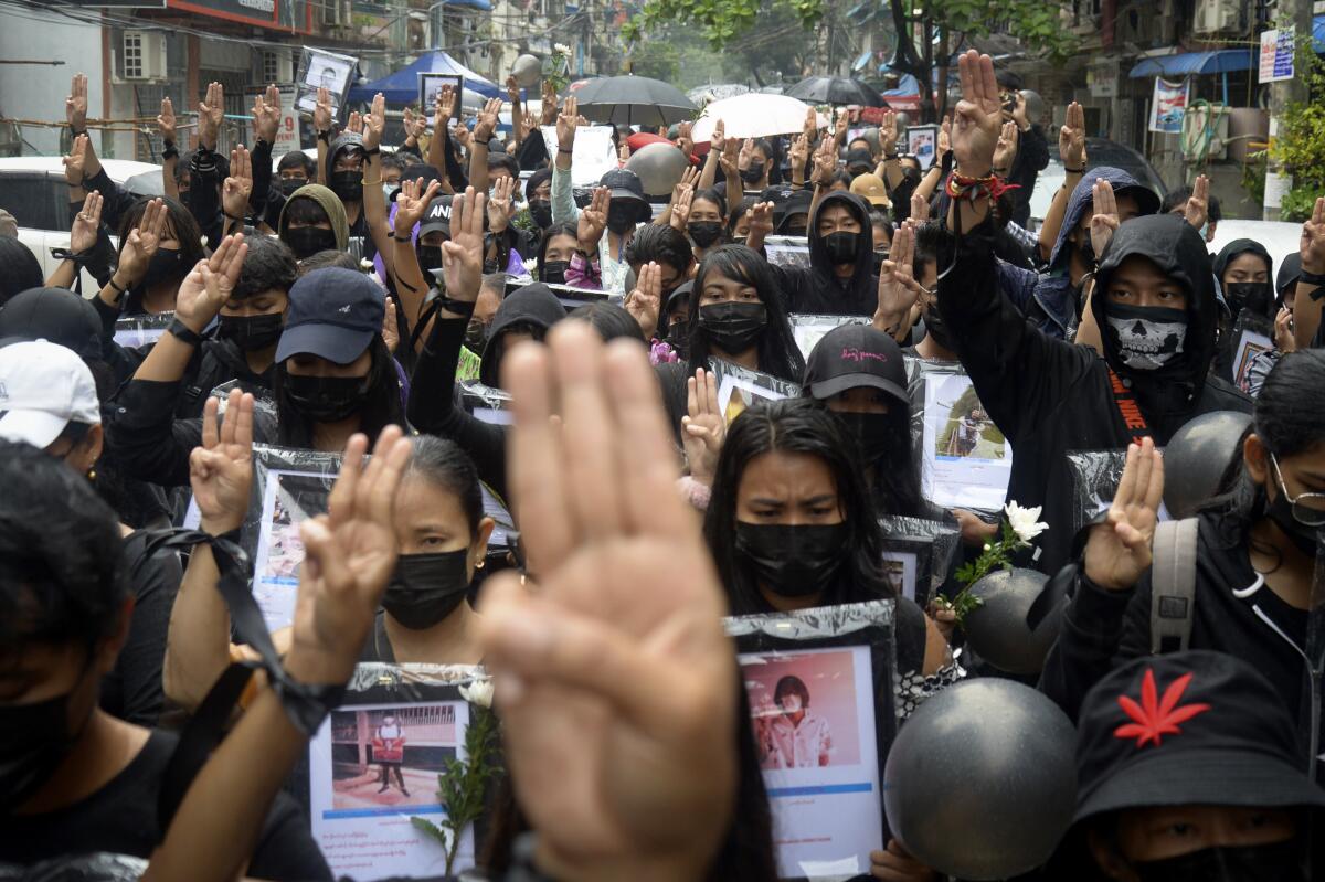 Anti-coup protesters flash three-fingered symbol of resistance as they gather to pray for those who died during a protest against the military in Yangon, Myanmar, Monday, April 5, 2021. Threats of lethal violence and arrests of protesters have failed to suppress daily demonstrations across Myanmar demanding the military step down and reinstate the democratically elected government. (AP Photo)