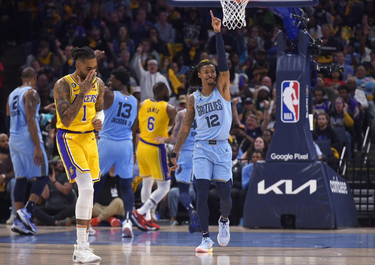Lakers guard D'Angelo Russell holds his hand to his face after Grizzlies guard Ja Morant celebrates his basket during Game 5.