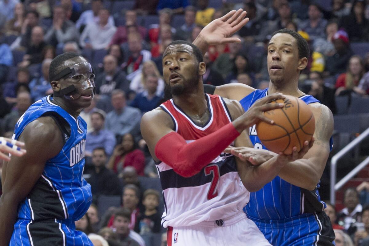 Washington's John Wall looks to pass the ball in front of Orlando's Victor Oladipo, left, and Channing Frye on Saturday night.