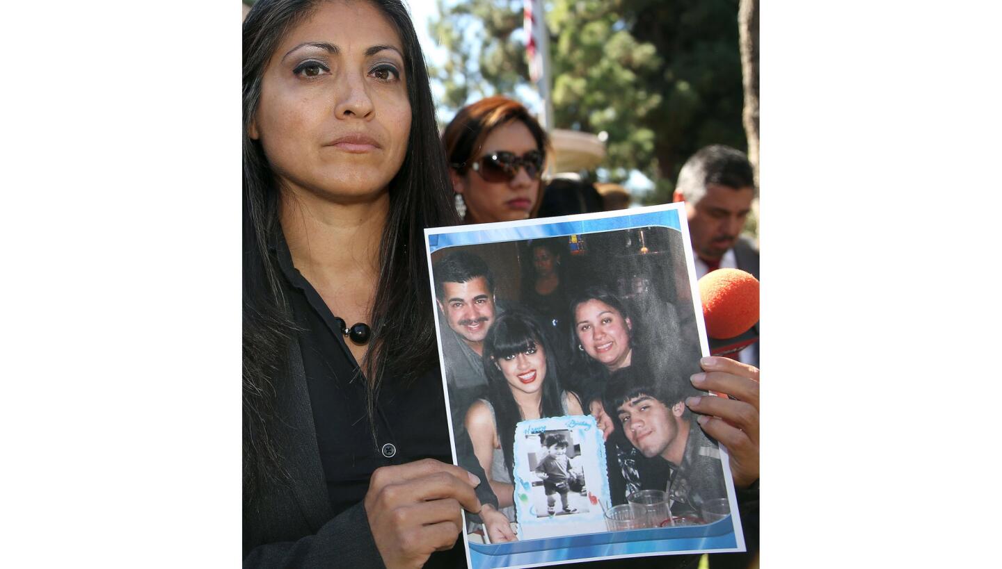 Attorney Claudia Osuna holds a photograph of the Crespo family: From left, Bell Gardens Mayor Daniel Crespo, daughter Crystal, wife, Lyvette, and son Daniel Jr.