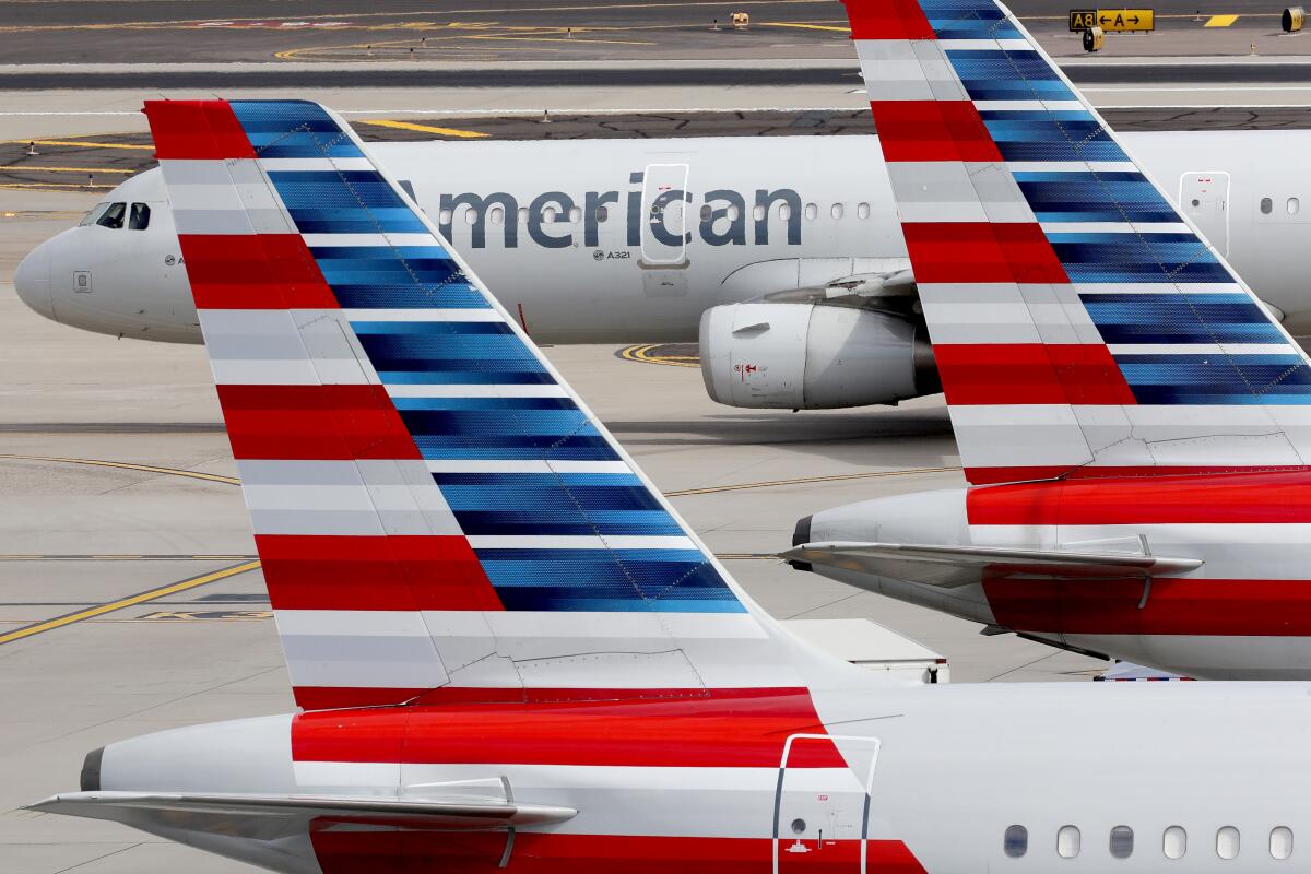 American Airlines jetliners are parked at an airport.