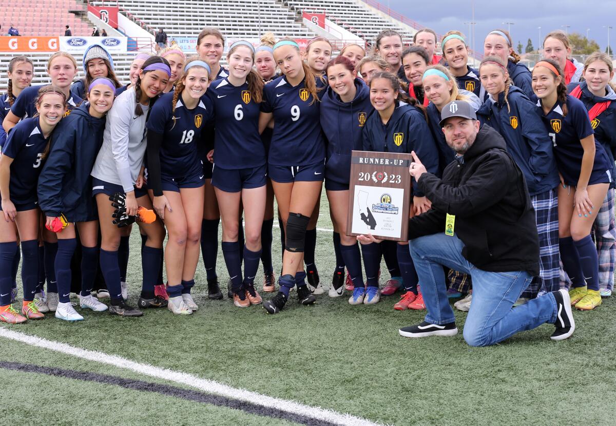 The Marina High girls' soccer team poses with the CIF runner-up plaque after dropping Saturday's match against Moorpark.