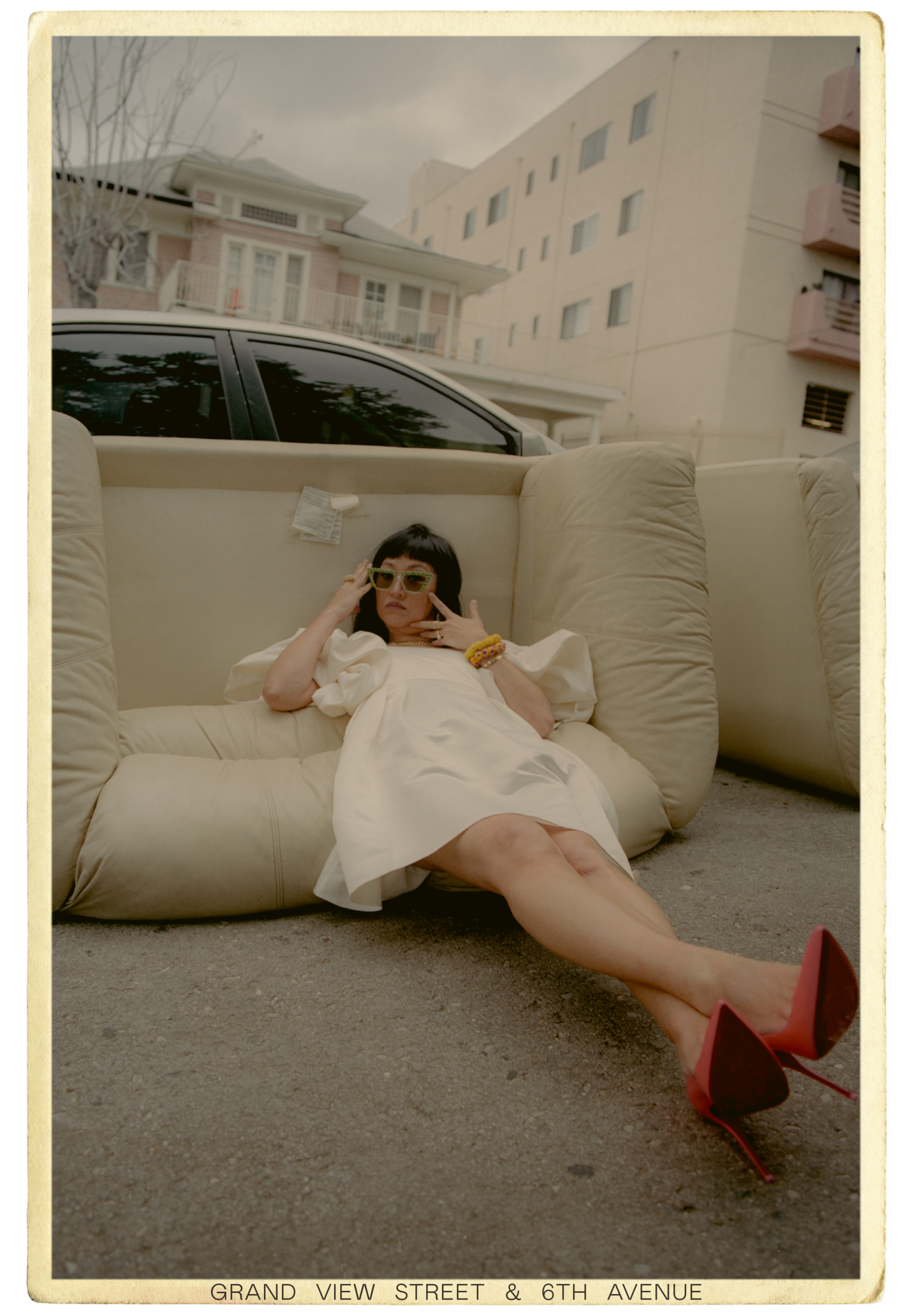 Christine Y. Kim lays on a couch left on the sidewalk