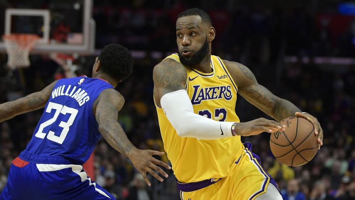 LeBron James drives past Clippers guard Lou Williams during the Lakers' overtime win on Jan. 31.