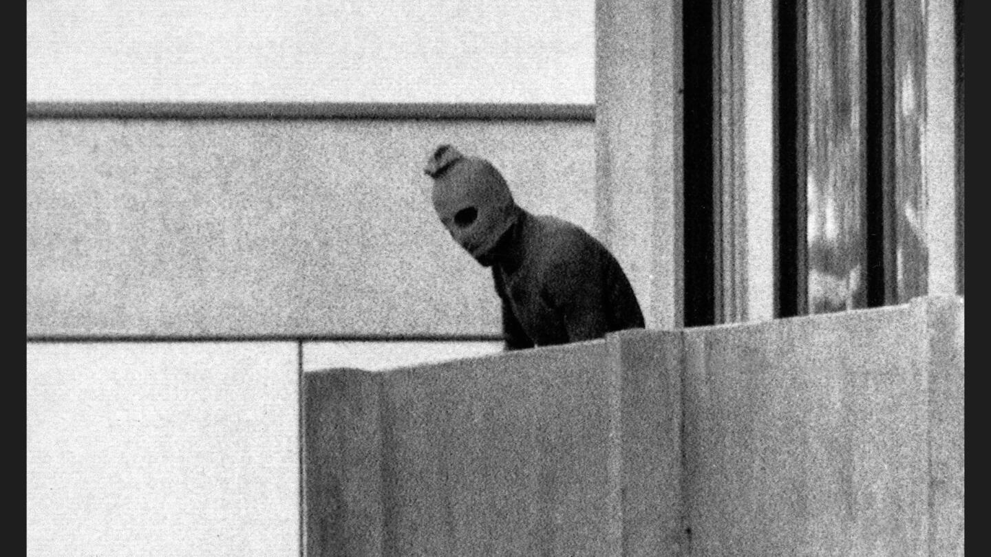 A member of the Palestinian militant group that held Israeli athletes and coaches hostage appears on a terrace at the Olympic Village in Munich during the Summer Games on Sept. 5, 1972. The militants were threatening to kill the hostages unless more than 200 Palestinian prisoners were released.
