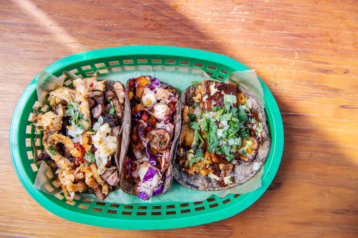 A spread of Máquina tacos including (from left), rib-eye and lobster, octopus, and mole pork belly.