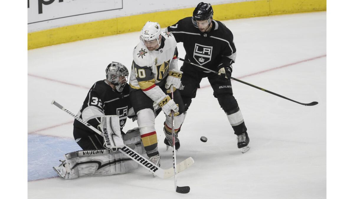 Kings goaltender Jonathan Quick keeps his focus on the puck as Golden Knights center Ryan Carpenter tries to deflect it past him and defenseman Oscar Fantenberg during the second period.