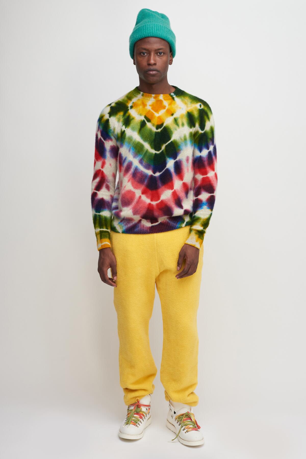 A model wears yellow pants and a tie-dye shirt from the Elder Statesman.