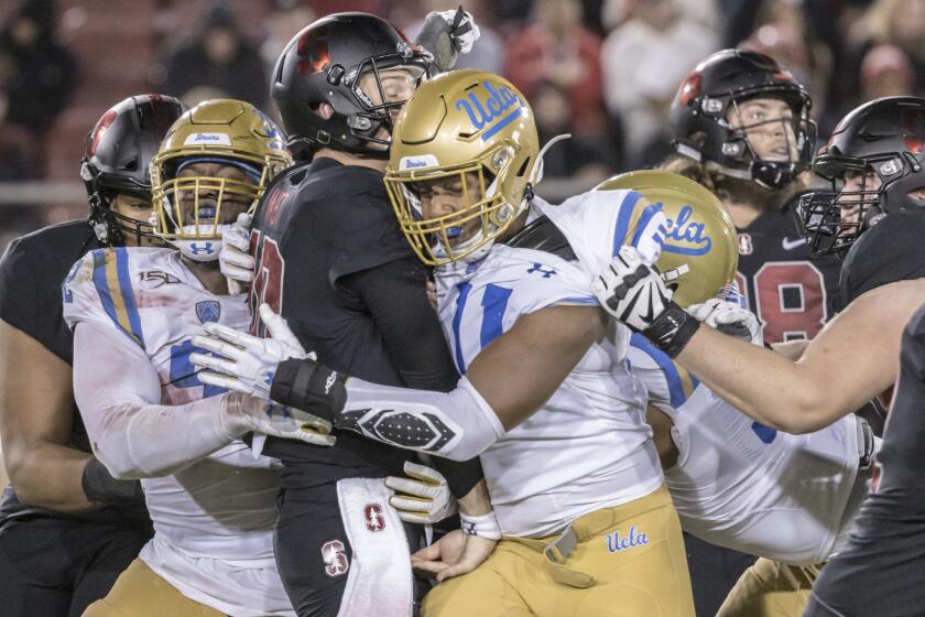 PALO ALTO, CA - OCTOBER 17: Jack West #10 of the Stanford Cardinal is hit by Osa Odighizuwa #92 (left) and Keisean Lucier-South #11 (right) of the UCLA Bruins after throwing a pass during an NCAA Pac-12 college football game on October 17, 2019 at Stanford Stadium in Palo Alto, California. (Photo by David Madison/Getty Images)