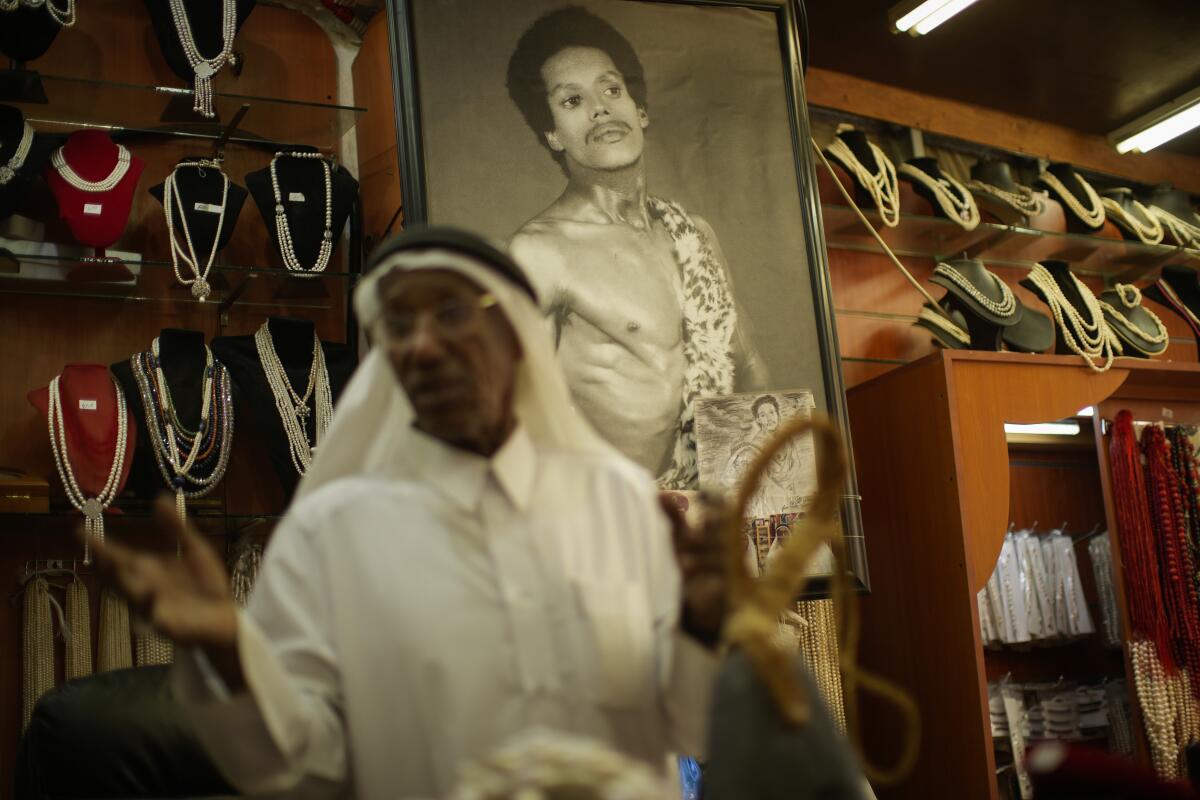 An old photograph of former pearl diver Saad Ismail Jassim hangs on a wall.