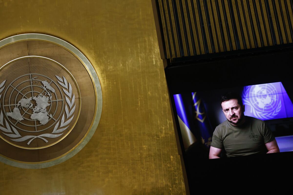 الرئيس الأوكراني فولوديمير زيلينسكي يتحدث على شاشة مع شعار الأمم المتحدة في المقدمة.