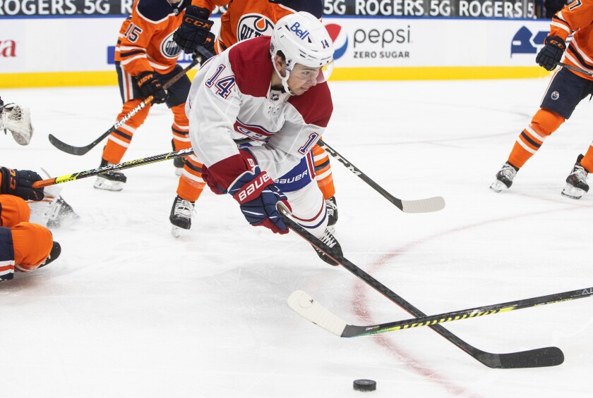 Montreal Canadiens' Nick Suzuki (14) dives for the puck against the Edmonton Oilers during first-period NHL hockey game action in Edmonton, Alberta, Saturday, Jan. 16, 2021. (Jason Franson/The Canadian Press via AP)