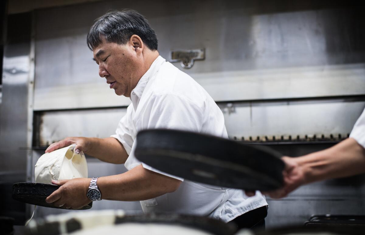 Youlen Chan pours cake batter into a pan at Phoenix Bakery in Chinatown, a family-owned establishment for more than 80 years. Working in the bakery as a teen was "a prerequisite of being part of the family," Chan says.