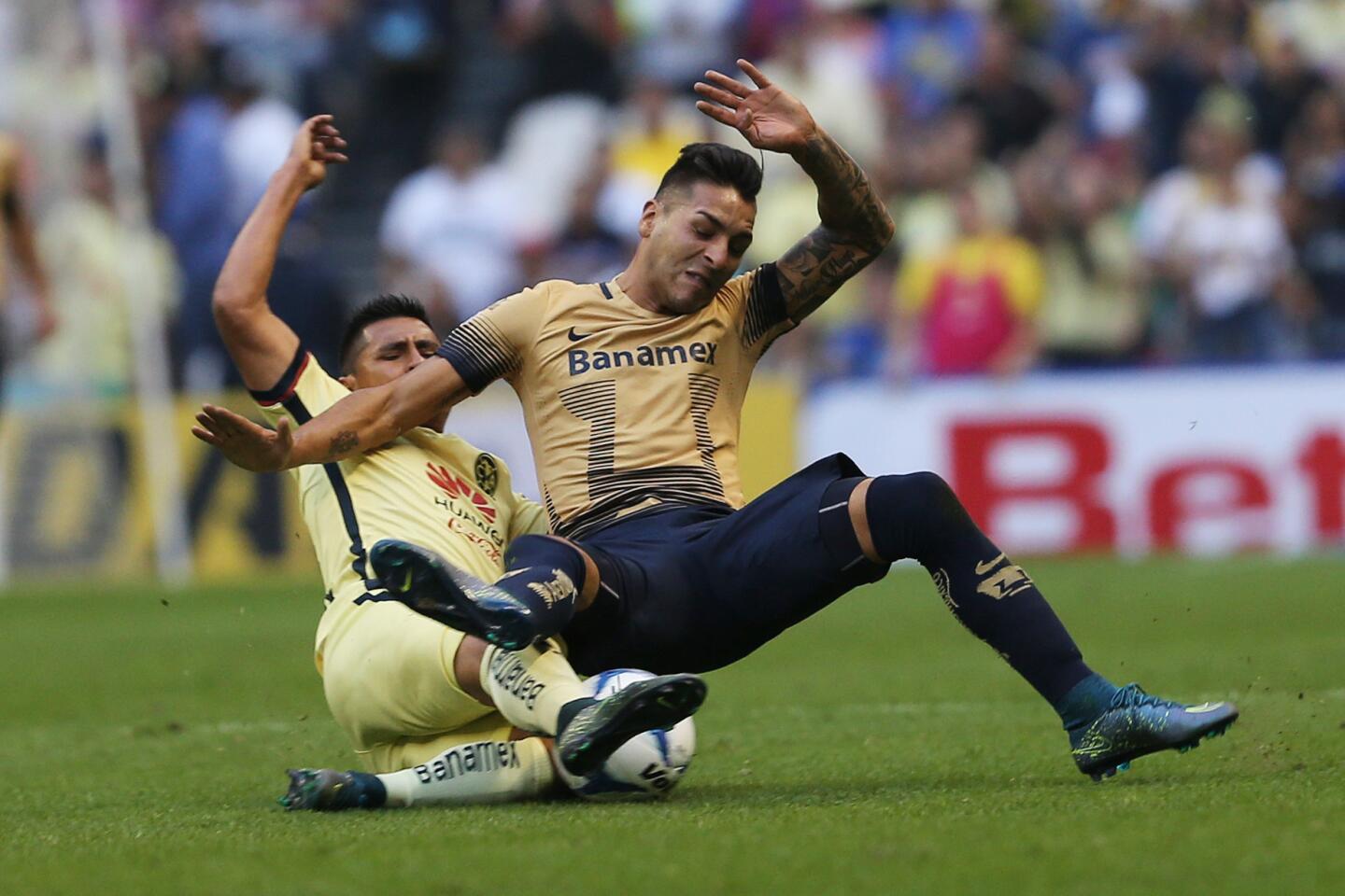 America's Osvaldo Martinez, left, and Pumas' Ismael Sosa, collide as they struggle for control of the ball, during a Mexican soccer league match in Mexico City, Saturday, Nov. 21, 2015.