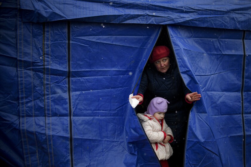 Refugees fleeing the conflict from neighbouring Ukraine exit a tent at the Romanian-Ukrainian border, in Siret, Romania, Thursday, March 3, 2022. The number of people sent fleeing Ukraine by Russia's invasion topped 1 million on Wednesday, the swiftest refugee exodus this century, the United Nations said, as Russian forces kept up their bombardment of the country's second-biggest city, Kharkiv, and laid siege to two strategic seaports. (AP Photo/Andreea Alexandru)