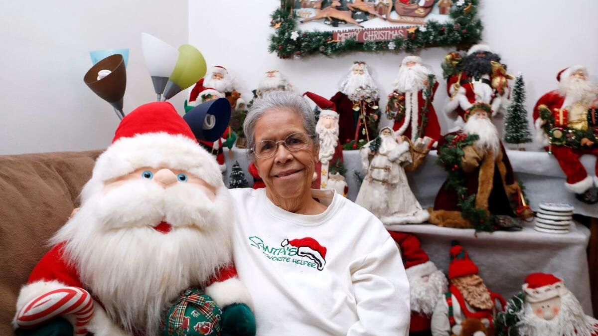 Maria Sands, 87, of Burbank has been collecting Santa Claus toys and items for about 35 years, sitting in her home on Tuesday. Sands has about 1,000 Santa Claus items.