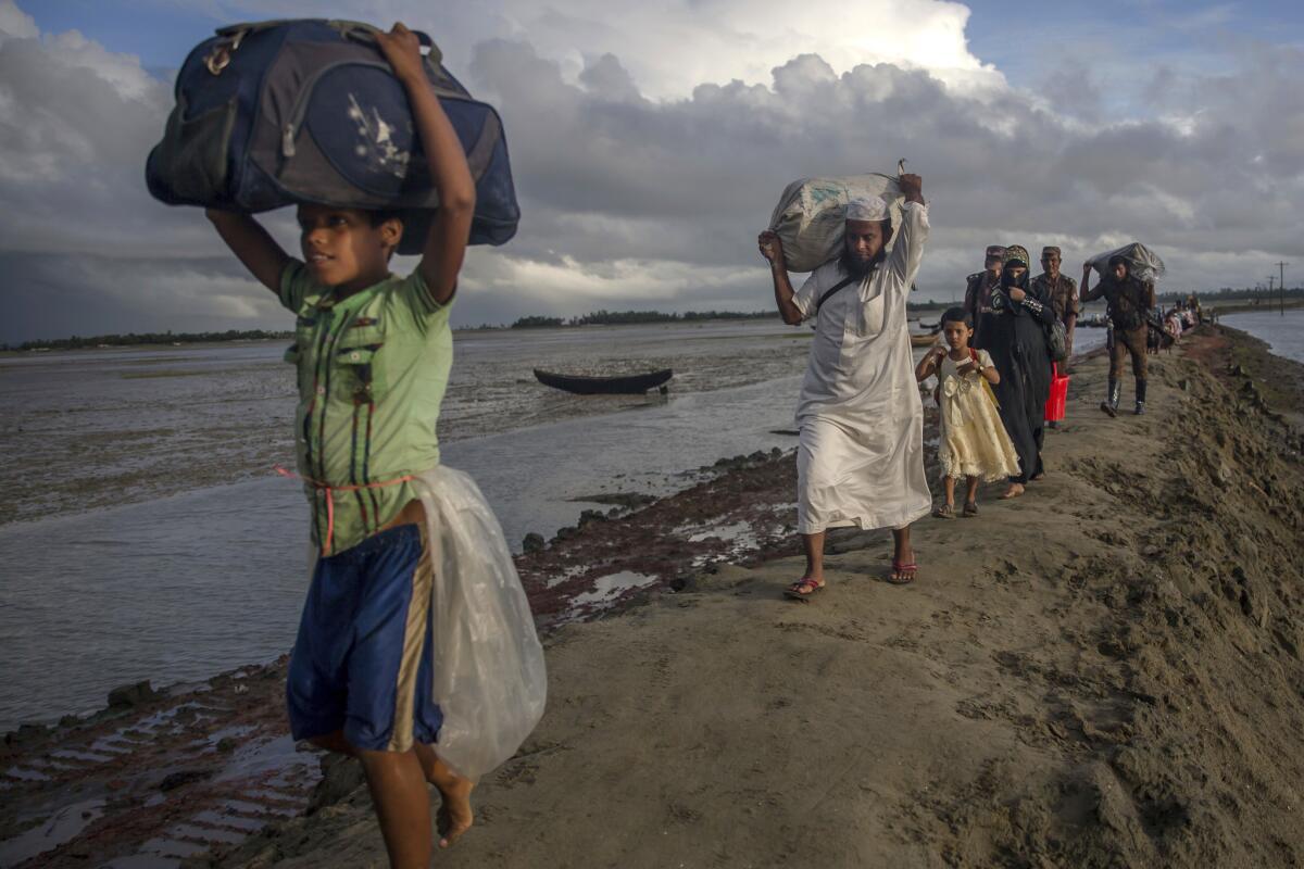 Newly arrived Rohingya Muslims walk with their belongings towards the nearest refugee camp at Teknaf, Bangladesh on Sept. 28, 2017.