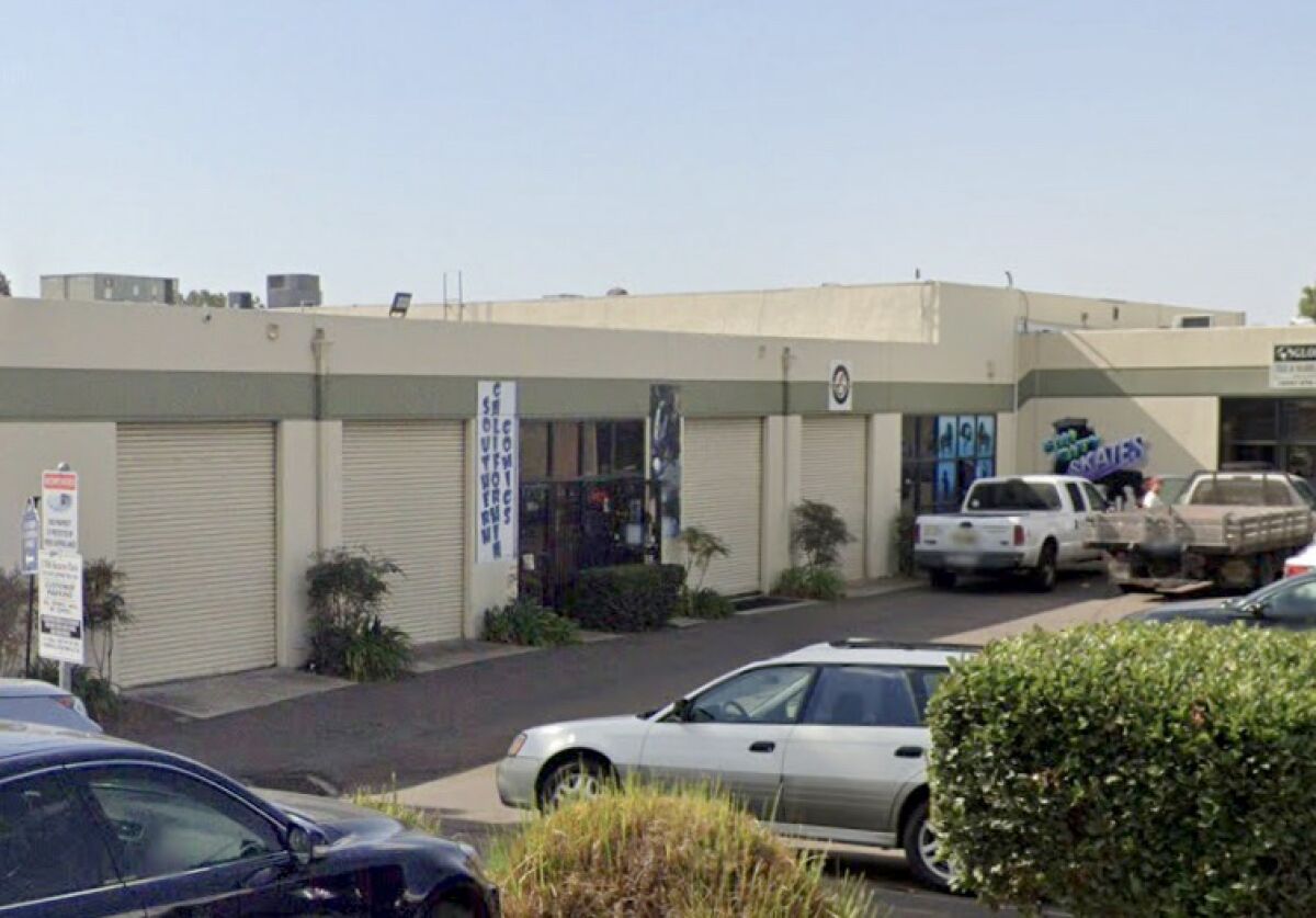 A large, beige warehouse in a parking lot