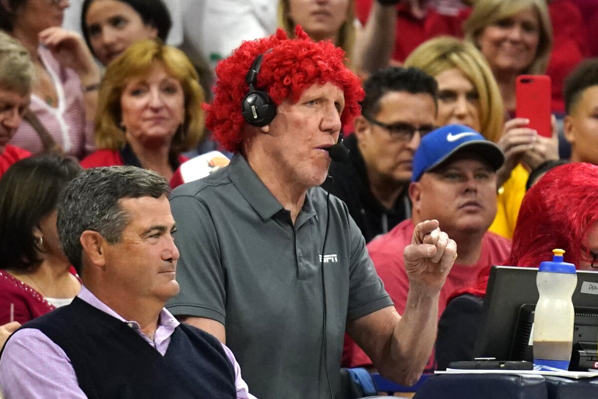 Bill Walton wears a red wig while broadcasting a game between Arizona and UCLA for ESPN.
