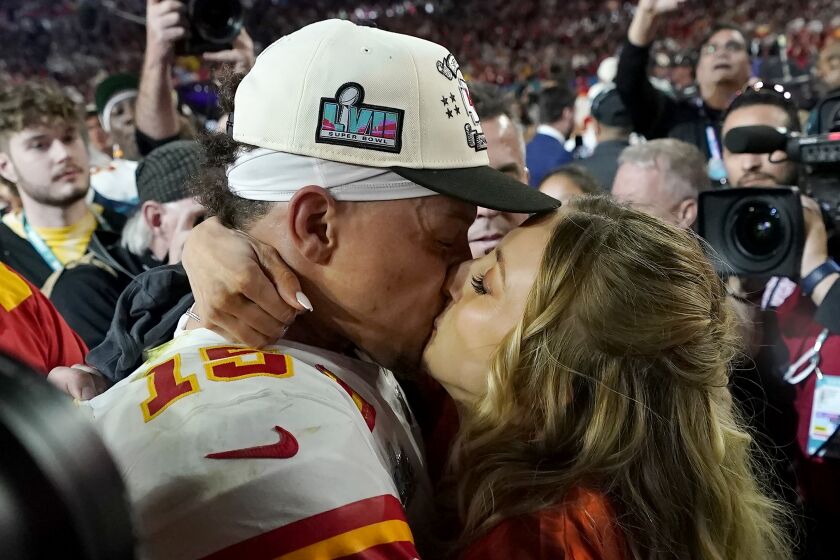 El quarterback Patrick Mahomes (15) de los Chiefs de Kansas City besa a su esposa, Brittany, tras vencer a los Eagles de Filadelfia en el Super Bowl 57, en Glendale, Arizona, el domingo 12 de febrero de 2023. (AP Foto/Marcio J. Sánchez)