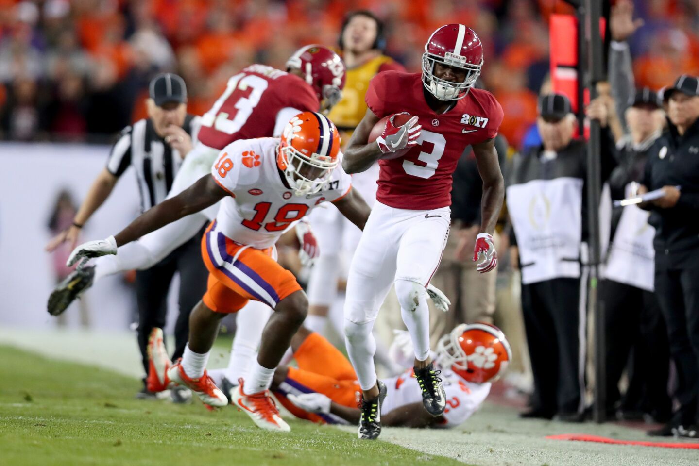 Alabama receiver Calvin Ridley tip-toes down the sideline after getting hit by Clemson defenders during the second quarter.