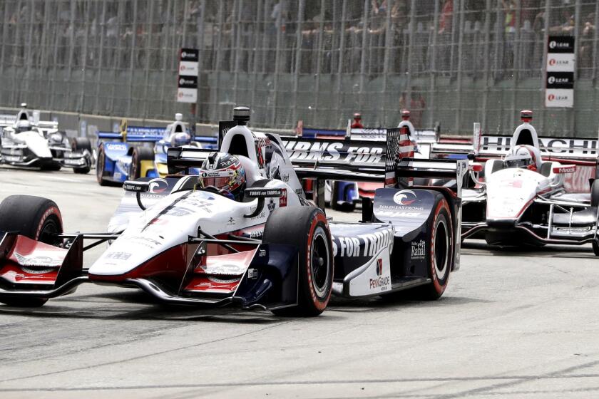 Graham Rahal, foreround, leads the field through the first turn during the first race of the IndyCar Detroit Grand Prix auto racing doubleheader, Saturday, June 3, 2017, in Detroit. (AP Photo/Carlos Osorio)