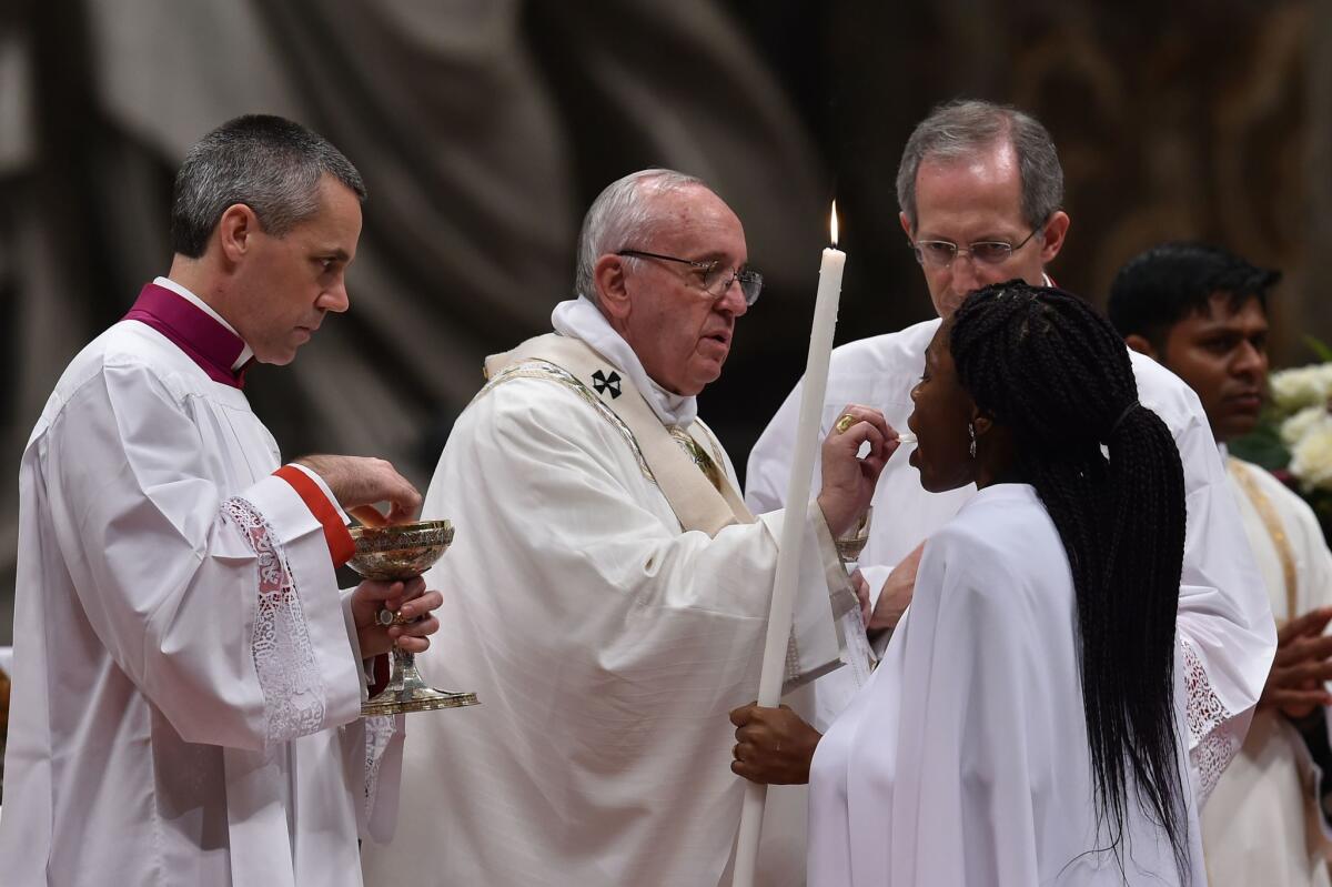 Pope Francis gives the Communion during the Easter Vigil at the St Peter's basilica in March.