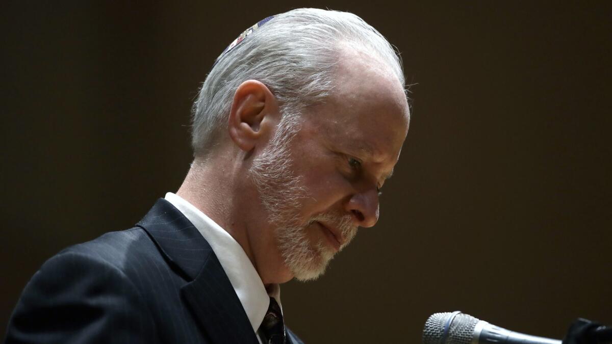 Rabbi Jeffrey Myers stands at the podium during a community gathering held in the aftermath of Saturday's deadly shooting at the Tree of Life Synagogue in Pittsburgh on Sunday.