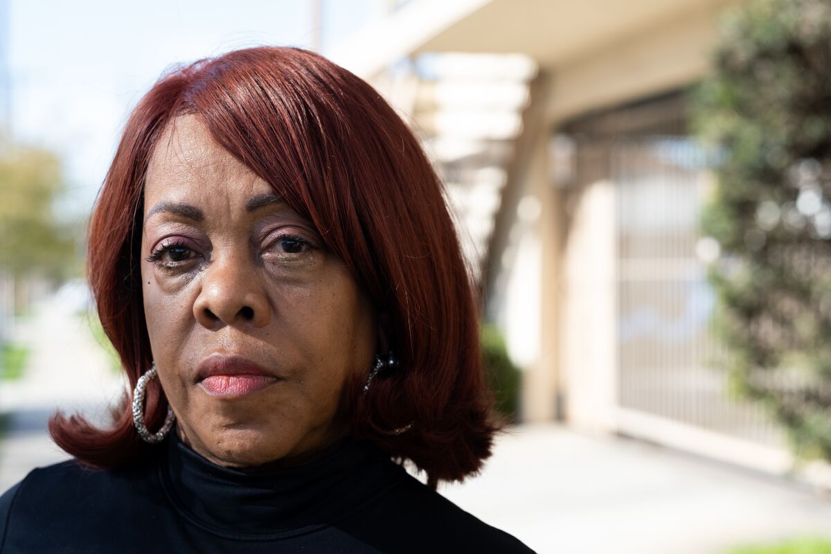 Close-up portrait of a woman standing outside her apartment building.