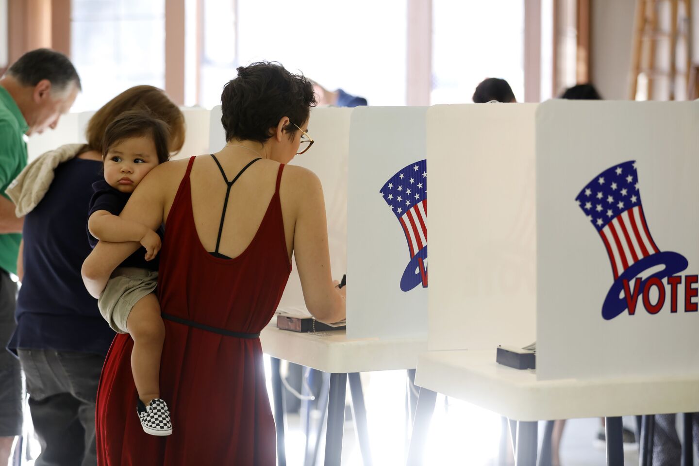 Rachel Mesa, 29, holds her son Madison Mesa, 1, as she votes at a polling site Tuesday in Stevenson Ranch, Calif.