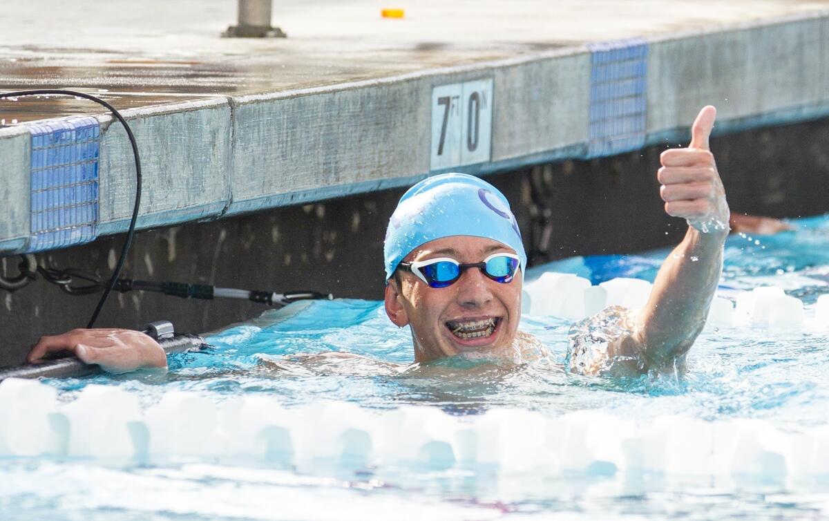 Corona del Mar High's Makar Briggs gives a thumbs up after finishing first in the 500-yard freestyle during the Battle of the Bay meet at Newport Harbor on Tuesday.